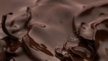 Koyu sıcak çikolata dalgalarının süper yavaş çekimi. Yüksek hızlı sinema kamerası, 1000fps.