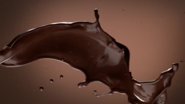 Koyu sıcak çikolatanın çok yavaş sıçratması. Yüksek hızlı sinema kamerası, 1000fps.