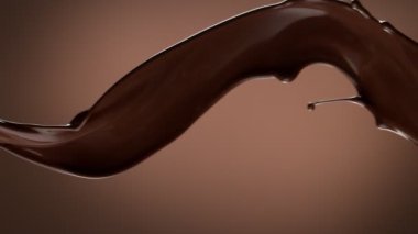 Koyu sıcak çikolatanın çok yavaş sıçratması. Yüksek hızlı sinema kamerası, 1000fps.
