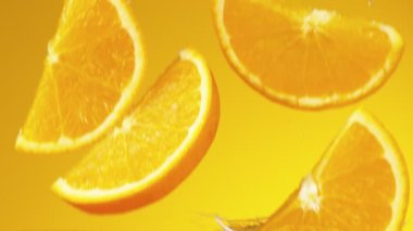 Portakal dilimlerinin çok yavaş bir şekilde meyve suyuna dökülmesi. Yüksek hızlı sinema kamerası, 1000 fps..