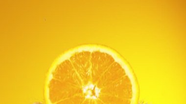 Portakal diliminin çok yavaş bir şekilde meyve suyuna dökülmesi. Yüksek hızlı sinema kamerası, 1000 fps..