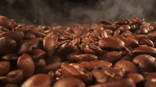 Stapel Verse Gebrande Koffiebonen Met Rook Buurt Heerlijke Koffie Achtergrond — Stockfoto