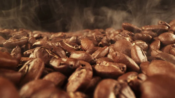 Stapel Verse Gebrande Koffiebonen Met Rook Buurt Heerlijke Koffie Achtergrond — Stockfoto