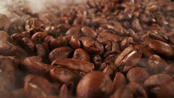 一堆新鲜的烤咖啡豆 周围都是烟 美味咖啡的背景 — 图库照片