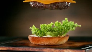 Çizburger parçalarını istiflemek için süper yavaş çekim. Yüksek hızlı sinema kamerası, 1000 fps..