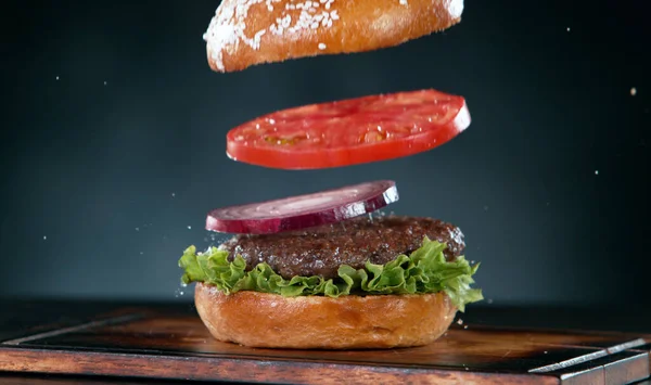 美味地在木制背景上堆放汉堡包 飞行食物的概念 — 图库照片