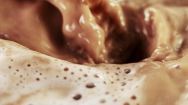 Köpüklü kahve içeceğine dökülen kahve içeceğinin ayrıntıları. Soyut kahve arkaplanı.