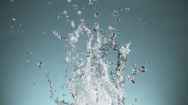 Mavi arka planda izole edilmiş çok yavaş su sıçratma hareketi. Yüksek hızlı sinema kamerası, 1000 fps..
