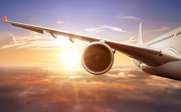 日没の光の中で雲の上を飛ぶ旅客機の翼の乗客の詳細 高速旅行 休日やビジネスの概念 — ストック写真