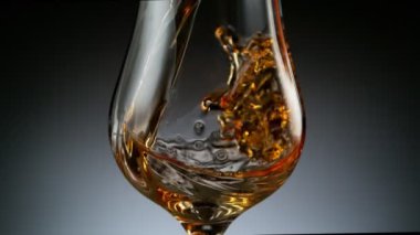 Konyağı cama boşaltmak için süper yavaş çekimde, hız rampası etkisi. Yüksek hızlı sinema kamerası, 1000 fps..