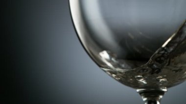 Beyaz şarabı bardağa doldururken çok yavaş hareket ediyor. Yüksek hızlı sinema kamerası, 1000 fps..