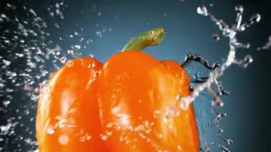 Turuncu biberi su sıçratarak döndürmek çok yavaş bir hareket. Yüksek hızlı sinema kamerası, 1000 fps..