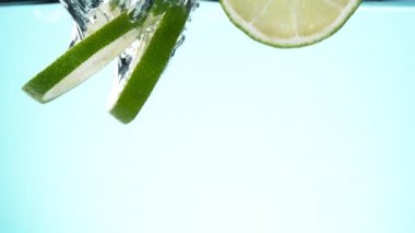 Düşen kireç dilimlerinin suya düşmesi süper yavaş bir hareket. Yüksek hızlı sinema kamerası, 1000 fps..