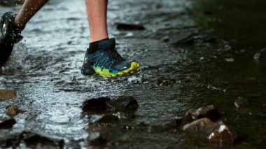 Nehirde koşan ve sağa sola sıçrayan adamın süper yavaş çekimi. Yüksek hızlı sinema kamerası, 1000 fps..