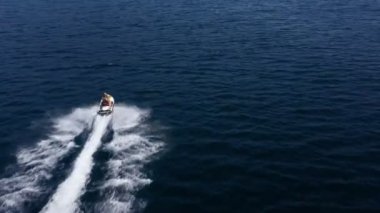 Hava aracı, jet ski 'nin denizi hızla aştığını gösteriyor. Süper hızlı seyahat, yaz tatili aktiviteleri, su taşımacılığı..