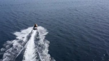 Hava aracı, jet ski 'nin denizi hızla aştığını gösteriyor. Süper hızlı seyahat, yaz tatili aktiviteleri, su taşımacılığı..