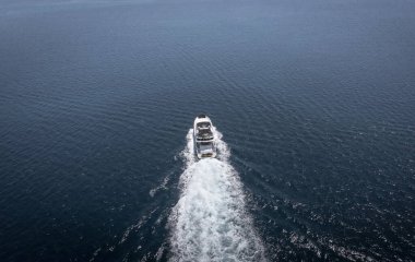 Lüks sürat teknesinin okyanus sularında yüzen havadan görünüşü zenginlik ve lüks seyahatin sembolü..
