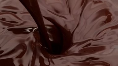 Kasırgaya dökülen koyu sıcak çikolatanın süper yavaş çekimi. Yüksek hızlı sinema kamerasıyla çekildi, 1000fps.