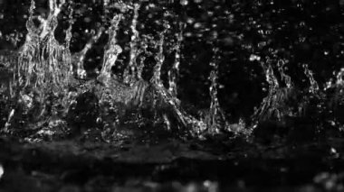 Siyah arka planda izole edilmiş çok yavaş su sıçratma hareketi. Yüksek hızlı sinema kamerası, 1000 fps.. 