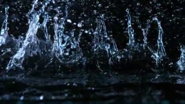 Siyah arka planda izole edilmiş çok yavaş su sıçratma hareketi. Yüksek hızlı sinema kamerası, 1000 fps.. 