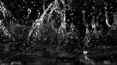 Siyah arkaplanda su sıçratma hareketini dondur. Stüdyo çekimi, ürün yerleştirme alanı.
