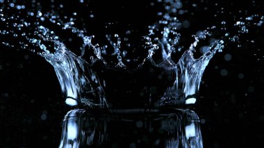 Suyun donmuş hareketi, taç şeklinde siyah arkaplanda sıçrıyor. Stüdyo çekimi, ürün yerleştirme alanı.