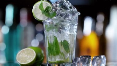 Mojito içeceğine düşen buz küpünün süper yavaş çekimi, kamera hareketi. Hız rampası etkisi. Yüksek hızlı sinema kamerası, 1000 fps..