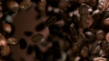 Uçan kahve çekirdeklerini çok yavaş çekiyorlar, dönüyorlar. Hız rampası etkisi. Yüksek hızlı sinema kamerası, 1000 fps..