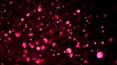 Siyah zemin üzerinde parıldayan neon parçacıklarının süper yavaş çekimi. Sığ odak derinliği. Yüksek hızlı sinema kamerası, 1000 fps..
