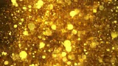 Siyah zemin üzerinde ışıldayan altın parçacıkların süper yavaş çekimi. Sığ odak derinliği. Yüksek hızlı sinema kamerası, 1000 fps..