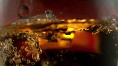 Süper makro çekimde buz küpünün viskiye dönüşmesi çok yavaş bir hareket. Hız rampası etkisi. Yüksek hızlı sinema kamerası, 1000fps