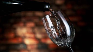 Beyaz şarabı bardağa doldururken çok yavaş hareket ediyor. Grunge 'un iç mimarisi. Yüksek hızlı sinema kamerası, 1000 fps.