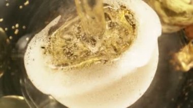 Kameranın hareketinin çok yavaş bir şekilde şampanya kadehine dönüşmesi. Su altı makro mercekli eşsiz bir açı. Kutlama ve başarı kavramı. Yüksek hızlı sinema kamerası, 1000 fps.