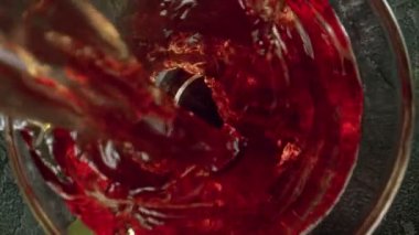 Kamera gücüyle kırmızı şarabı cama dökmenin süper yavaş çekimi. Su altı makro mercekli eşsiz bir açı. Hız rampası etkisi. Yüksek hızlı sinema kamerası, 1000 fps..