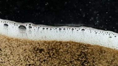 Şampanya kabarcıkları ve köpük dokusunun süper yavaş çekimi. Siyah arka planda izole edilmiş. Yüksek hızlı sinema kamerası, 1000 fps.