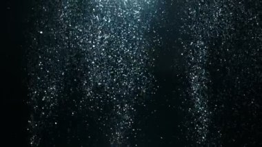 Siyah arkaplanda ışıldayan mavi parçacıkların süper yavaş çekimi. Yüksek hızlı sinema kamerası, 1000 fps..