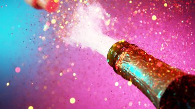 Şampanya patlaması, uçan şarap sıçramalarının dondurucu hareketi. Neon ışıkları. Kutlama konsepti, mutlu yıllar teması.