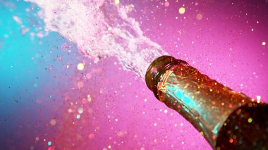 Şampanya patlaması, uçan şarap sıçramalarının dondurucu hareketi. Neon ışıkları. Kutlama konsepti, mutlu yıllar teması.