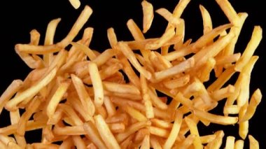 Siyah arka planda uçan patates kızartmalarının süper yavaş çekimi. Yüksek hızlı sinema kamerası, 1000 fps..