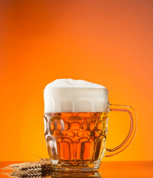 Glass of beer with orange background — Stock Photo, Image