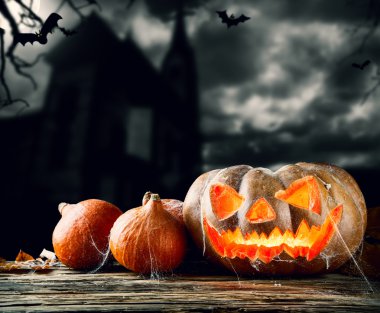 Halloween pumpkins on wood with dark background clipart