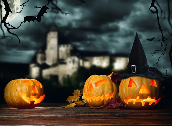 Halloween pompoenen op hout met donkere achtergrond — Stockfoto