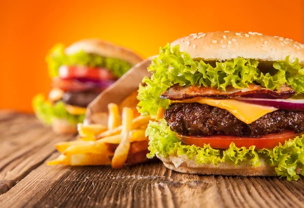 Hamburguesas frescas en tablones de madera — Foto de Stock