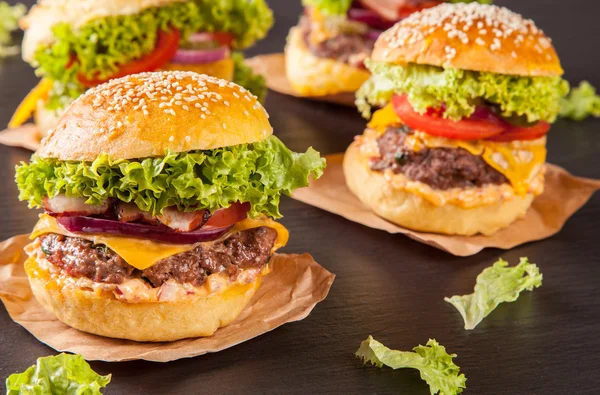 Fresh hamburgers served on black stone — Stock Photo, Image