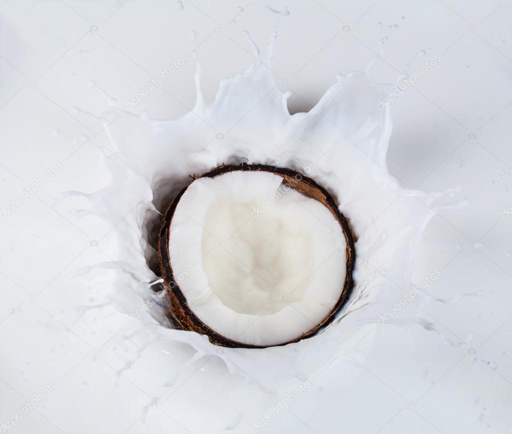Coconut falling into milk splashes