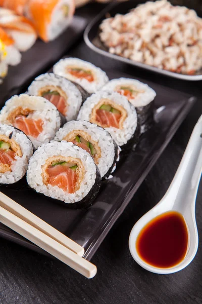 Läckra sushi bitar serveras på svart sten — Stockfoto