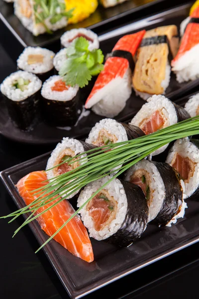 Lahodné sushi kousků na černý kámen — Stock fotografie