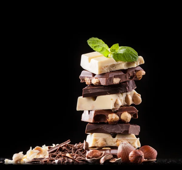 Stapel van hazelnoot chocolade op zwarte achtergrond — Stockfoto