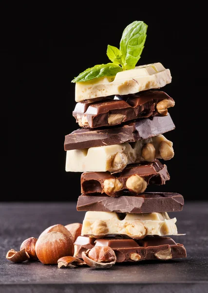 Stapel van hazelnoot chocolade op zwarte achtergrond — Stockfoto