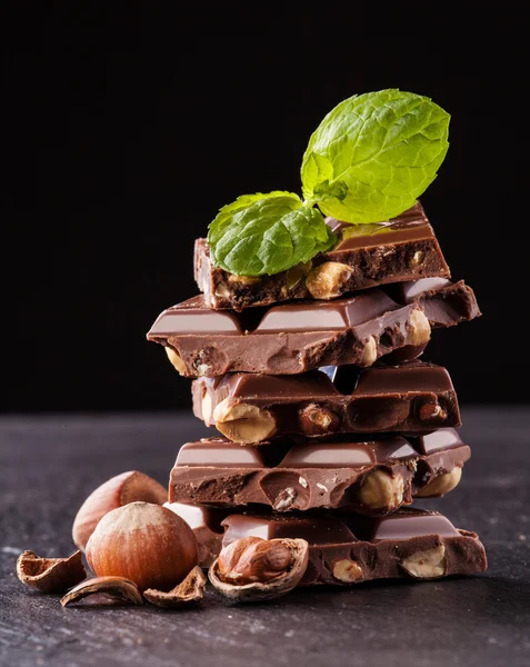 Stapel van hazelnoot chocolade op zwarte achtergrond — Stockfoto